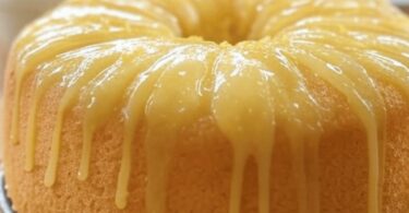 Gâteau au citron moelleux tranché, imbibé de sirop et garni de zeste
