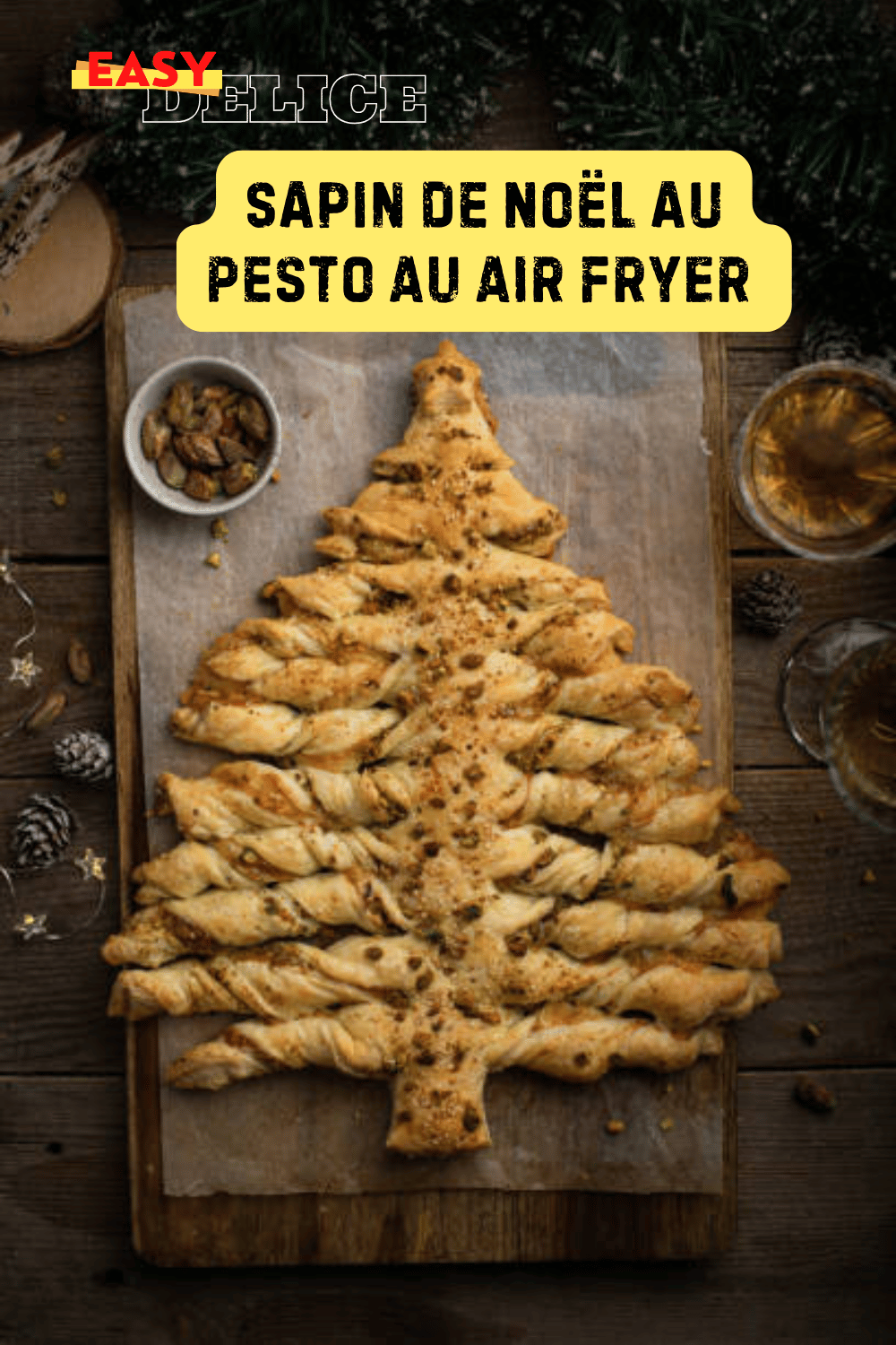 Sapin de Noël feuilleté au pesto, doré et prêt à être servi sur un plateau festif.