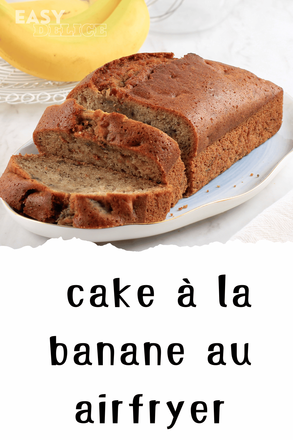 Banana bread moelleux et doré, servi avec des tranches de banane et des noix en garniture.

