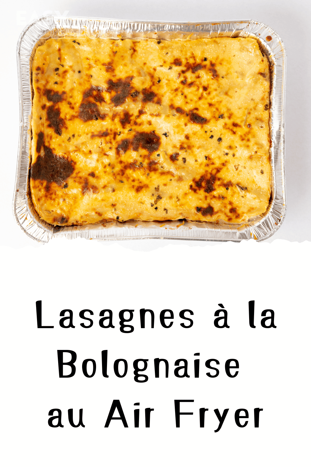 Lasagnes dorées à la bolognaise, servies dans un plat individuel avec des herbes fraîches en garniture.