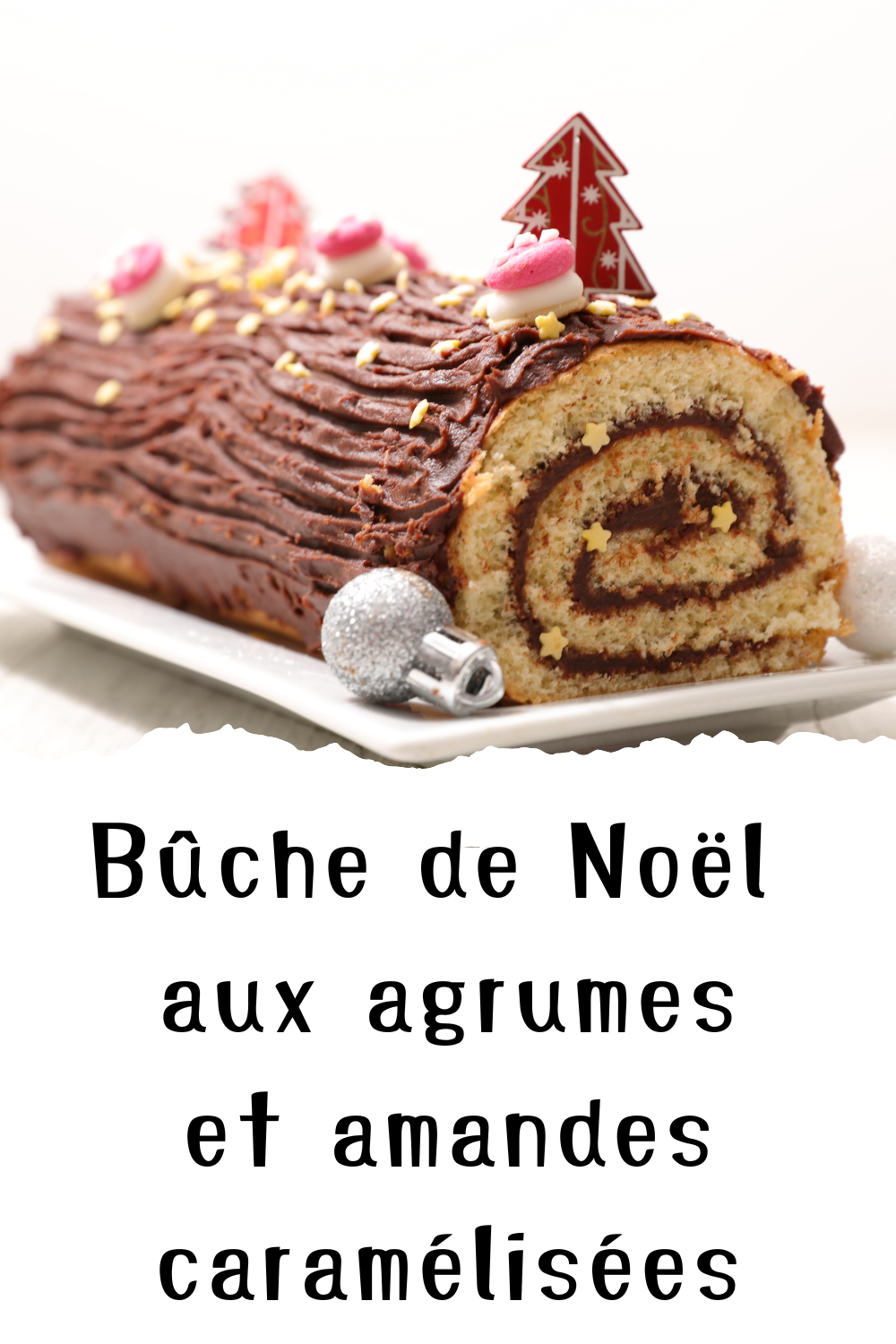 Bûche de Noël aux agrumes et amandes caramélisées, joliment présentée avec des zestes et des décorations festives.