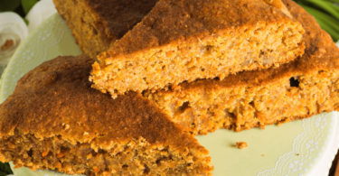 Cake aux pommes moelleux, délicatement épicé, servi sur une assiette avec une tranche découpée.