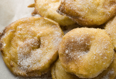 Beignets aux pommes dorés, saupoudrés de sucre glace et prêts à déguster.