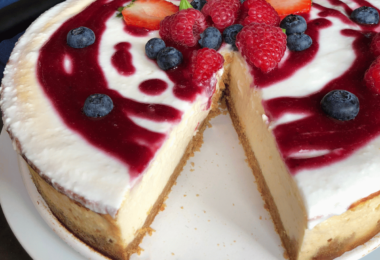 Cheesecake aux fraises garni de fraises fraîches et coulis.