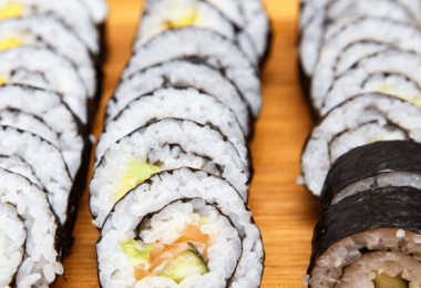 Plateau de sushis maison, avec makis et nigiris, joliment présentés sur une assiette.