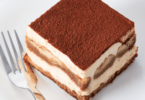 Tiramisu classique, en couches parfaites, avec une finition de cacao en poudre.