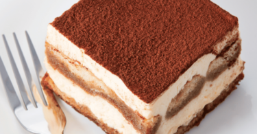 Tiramisu classique, en couches parfaites, avec une finition de cacao en poudre.