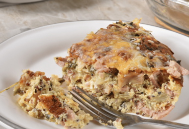 Quiche sans pâte dorée, garnie de légumes et de fromage, servie dans un plat rustique.