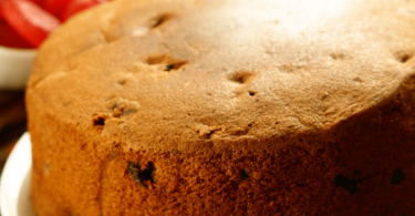 Gâteau sans sucre pour diabétiques, garni de fruits frais, servi sur une assiette.