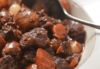 Plat de bœuf bourguignon avec morceaux de bœuf, carottes, champignons et persil