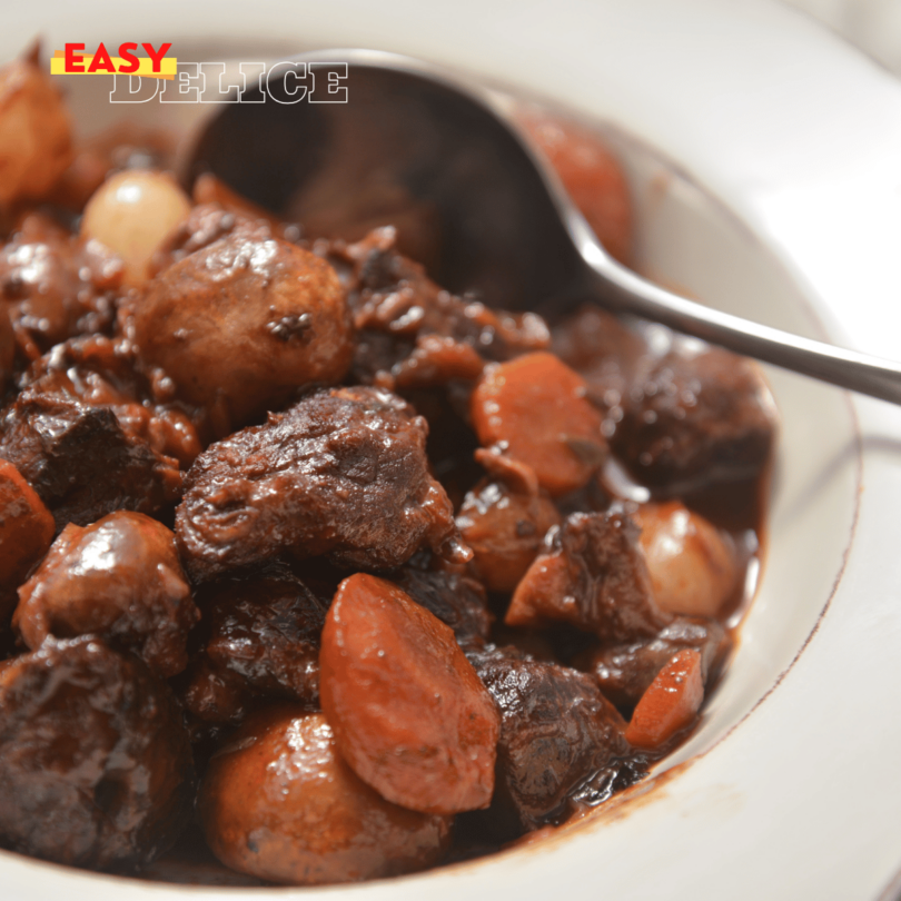 Plat de bœuf bourguignon avec morceaux de bœuf, carottes, champignons et persil