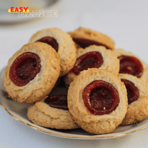 Biscuits aux amandes avec un cœur de confiture, dorés et saupoudrés de sucre glace.