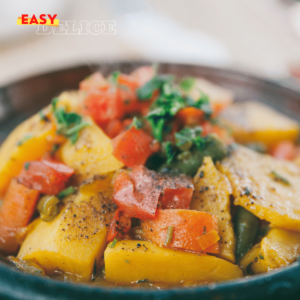 Tajine de poulet aux épices avec légumes et olives, servi dans un plat en terre cuite.