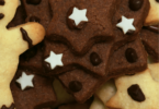 Sablés de Noël au chocolat, décorés avec du glaçage blanc et des motifs festifs.