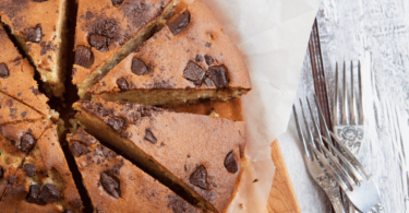 Gâteau moelleux aux pépites de chocolat présenté sur une assiette avec une texture gourmande et des éclats fondants.