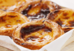 Pasteis de nata dorés et crémeux avec une touche de cannelle, prêts à être dégustés