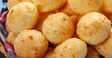 Pão de Queijo moelleux, dorés et croustillants, disposés sur une assiette.