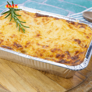 Lasagnes dorées à la bolognaise, servies dans un plat individuel avec des herbes fraîches en garniture.