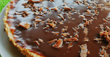 Tarte aux Daims, nappée de caramel et parsemée de morceaux de chocolat croquant.