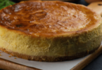 Gâteau basque doré avec une garniture crémeuse au citron, servi dans une assiette élégante.