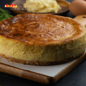 Gâteau basque doré avec une garniture crémeuse au citron, servi dans une assiette élégante.