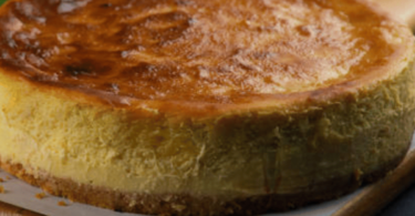 Gâteau basque doré avec une garniture crémeuse au citron, servi dans une assiette élégante.