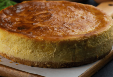 Gâteau basque doré avec une garniture crémeuse au citron, servi dans une assiette élégante.