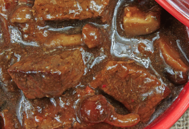 Carbonnade flamande mijotée, servie avec des frites croustillantes et une bière belge.