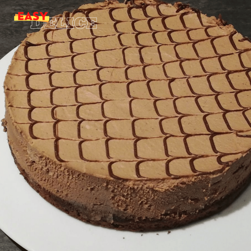 Gâteau Despacito au chocolat, nappé de ganache brillante et servi sur une assiette élégante.