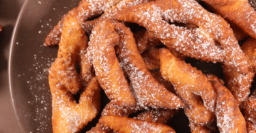 Bugnes dorées et légères préparées au Air Fryer, saupoudrées de sucre glace.