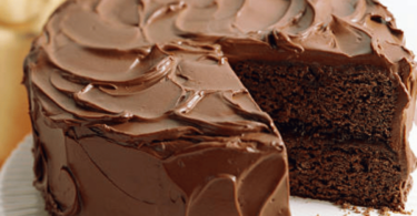 Gâteau au chocolat classique, moelleux et fondant, servi avec une touche de crème fouettée.