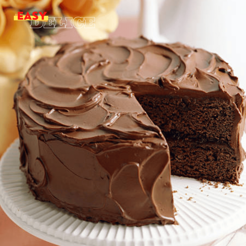 Gâteau au chocolat classique, moelleux et fondant, servi avec une touche de crème fouettée.