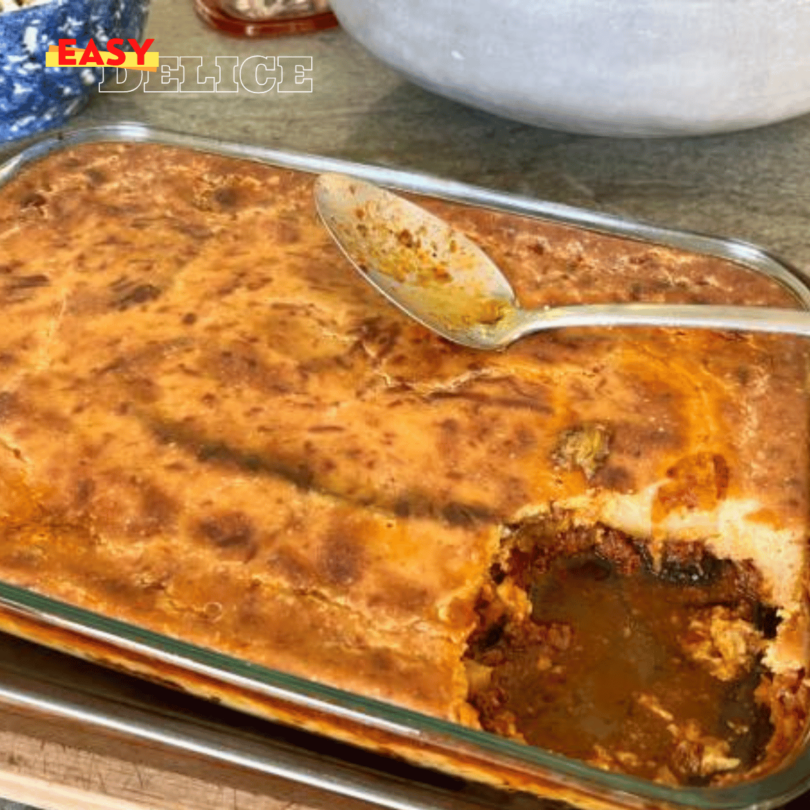 Moussaka grecque traditionnelle, dorée et servie en parts généreuses dans une assiette.