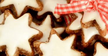 Biscuits de Noël à la cannelle, joliment décorés et disposés sur une table festive.