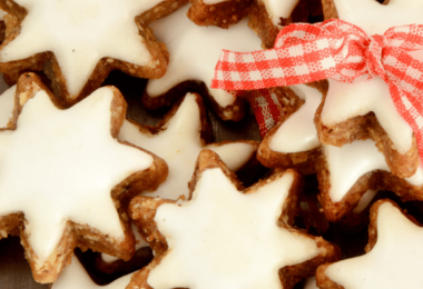 Biscuits de Noël à la cannelle, joliment décorés et disposés sur une table festive.