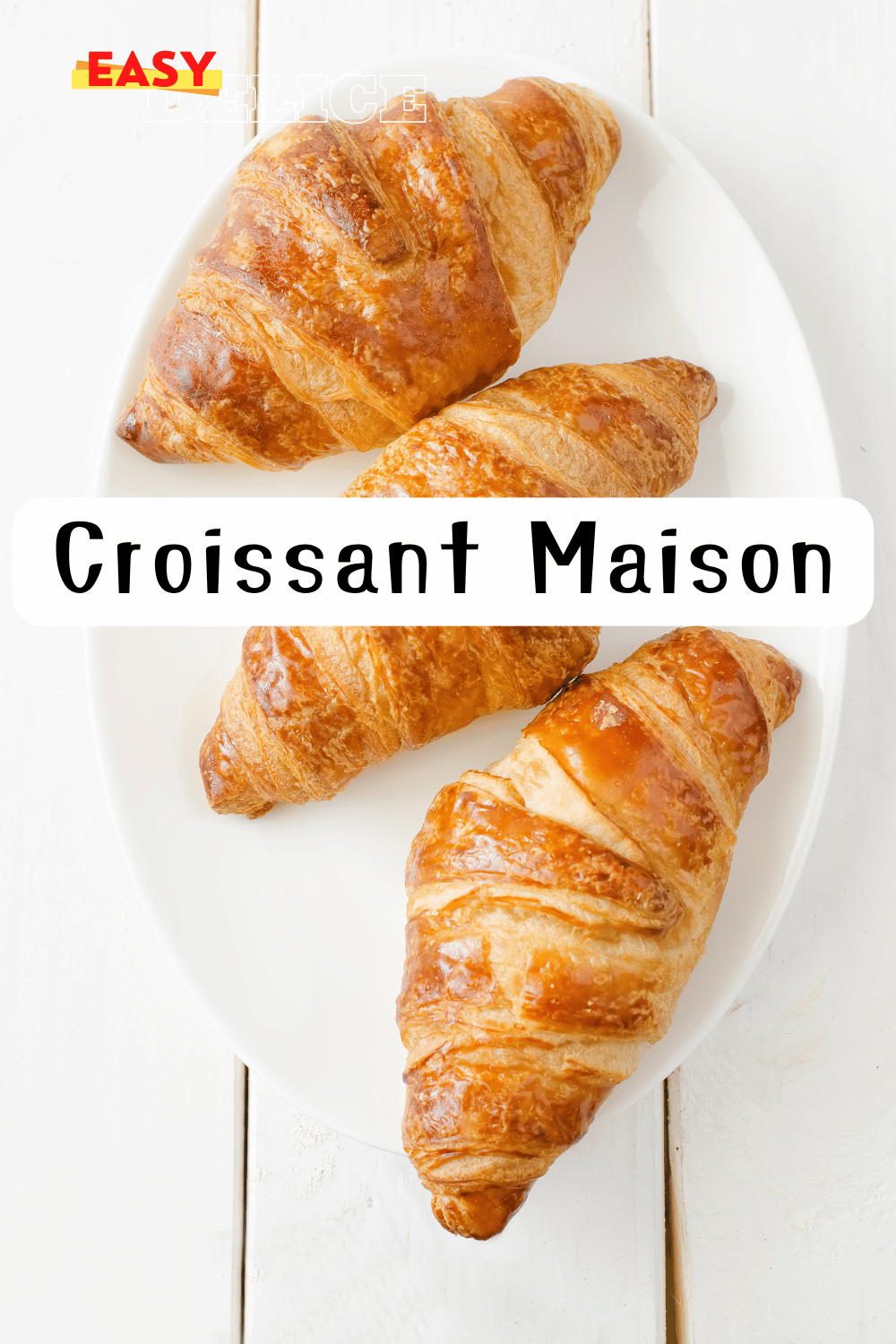 Croissants dorés et croustillants posés sur une grille de refroidissement, accompagnés d’un bol de café.