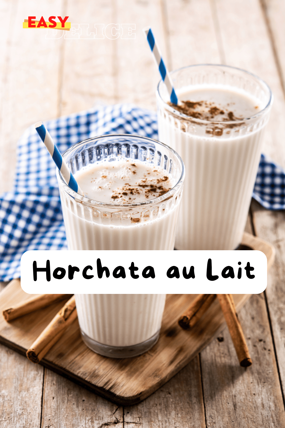 Horchata au lait servie dans un verre, décorée avec une pincée de cannelle et une tige de cannelle en garniture.