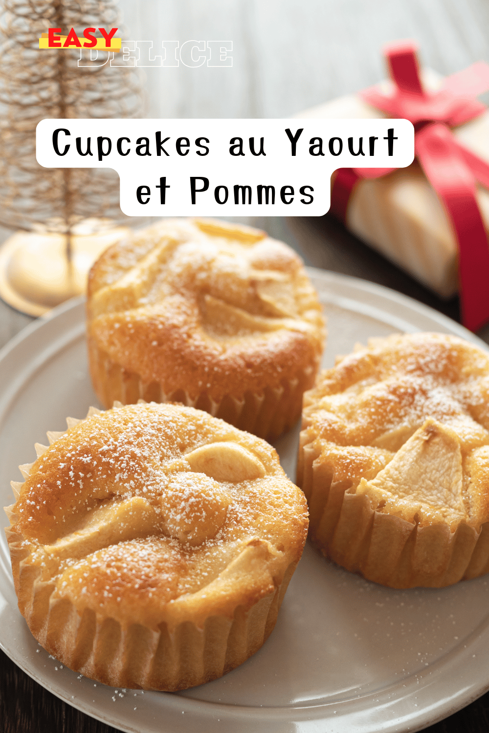 Cupcakes au yaourt et pommes dorés, surmontés de morceaux de pommes et saupoudrés de sucre glace