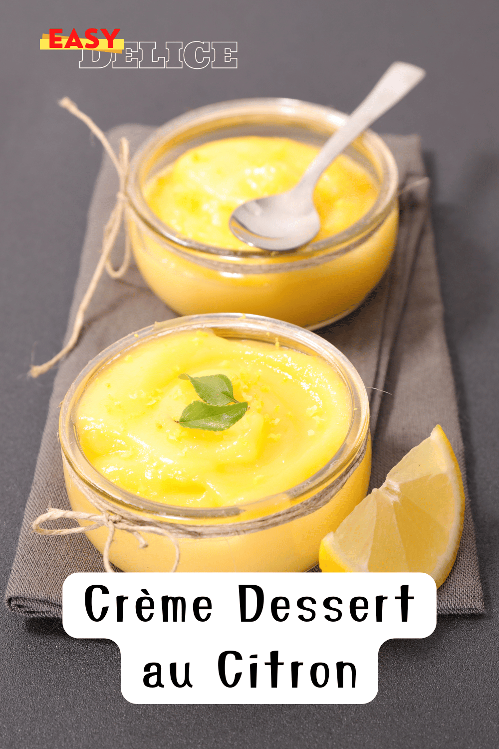 Crème dessert au citron dans un verre décoré de zestes de citron frais et d’un brin de menthe.