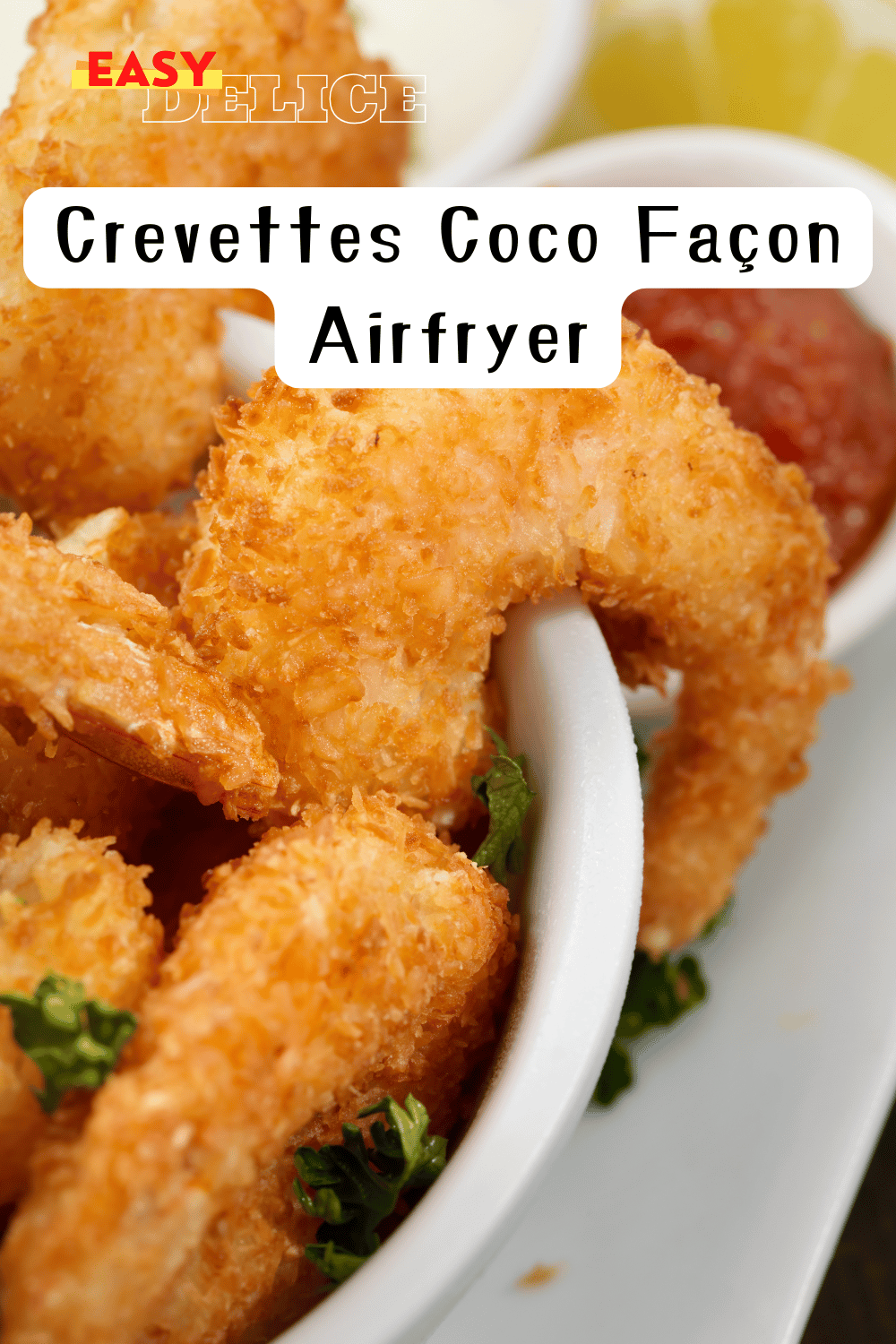  Crevettes coco dorées servies avec une sauce épicée et citron vert
