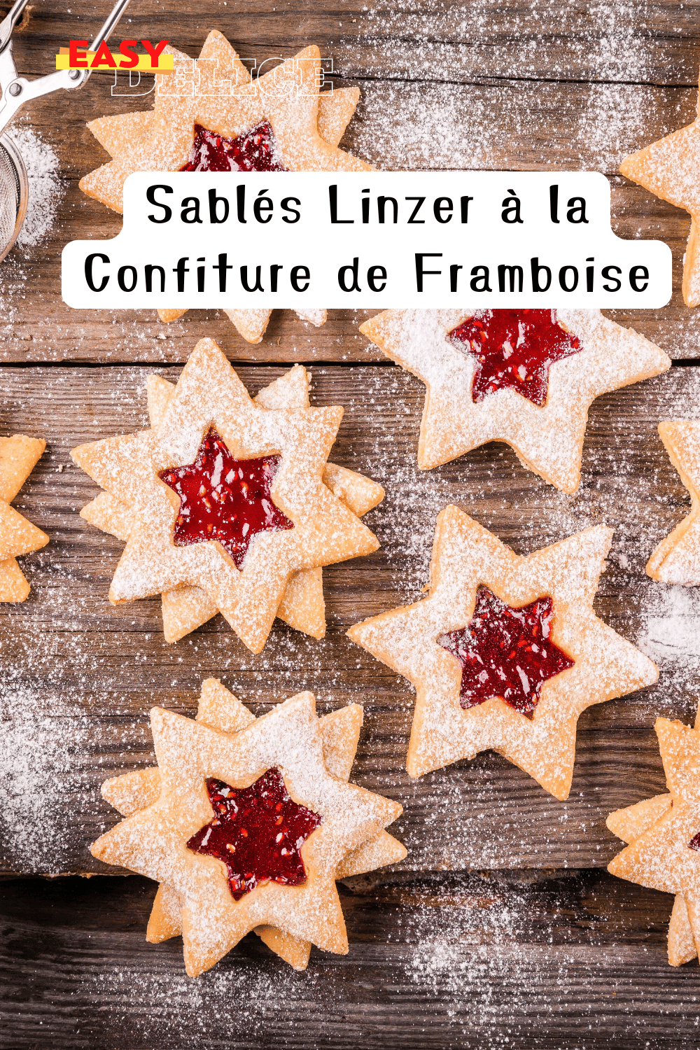 Sablés Linzer garnis de confiture de framboise, saupoudrés de sucre glace sur une assiette festive.