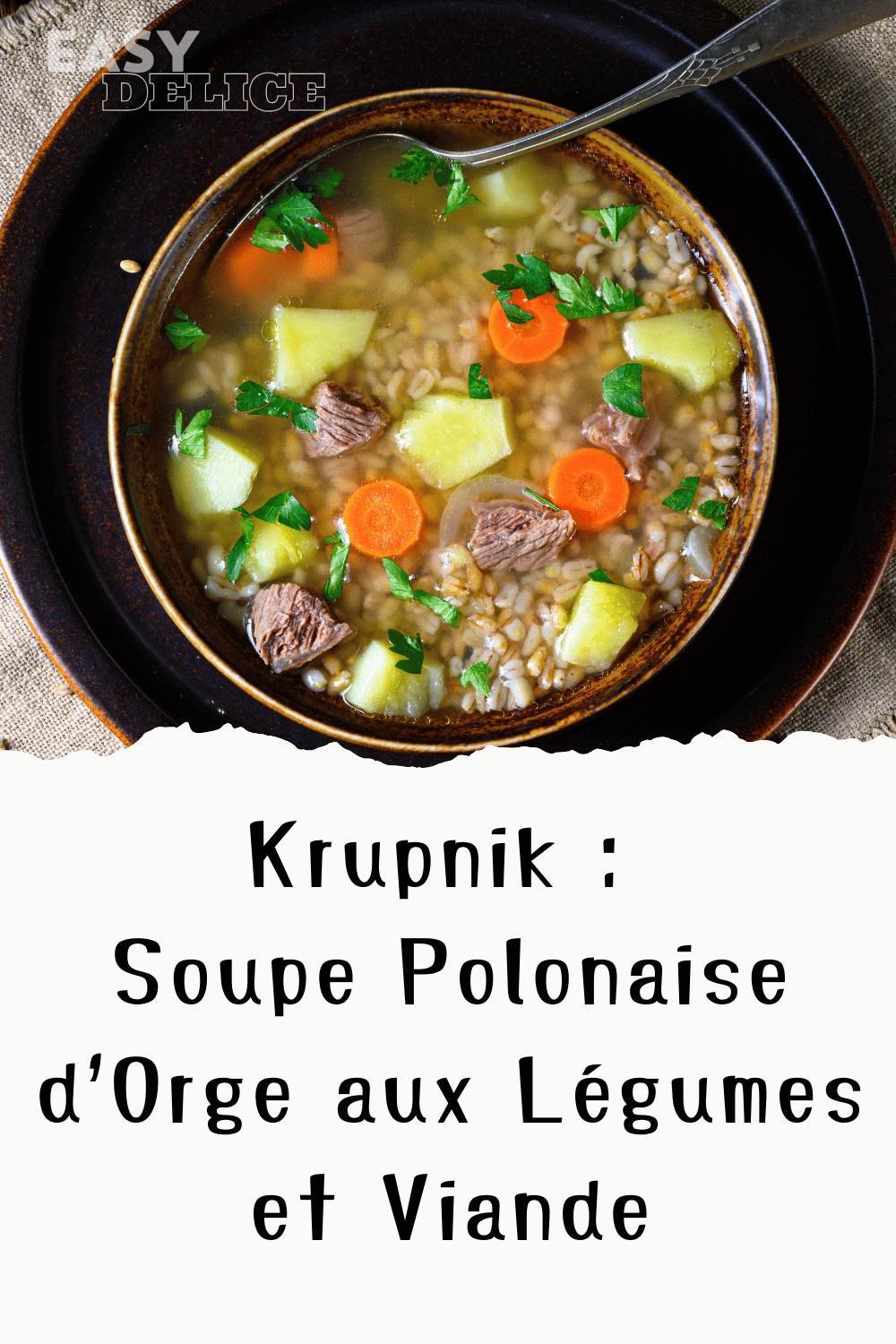 Bol de Krupnik polonais avec orge, légumes et viande, servi chaud avec du persil frais.