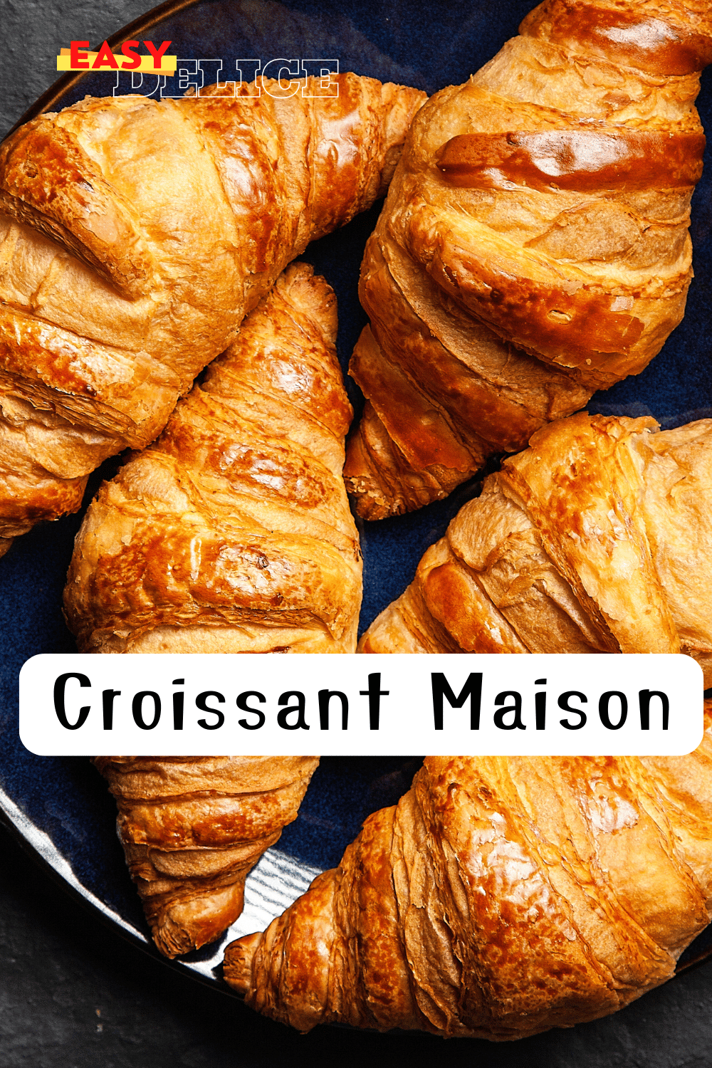 Croissants dorés et croustillants posés sur une grille de refroidissement, accompagnés d’un bol de café.