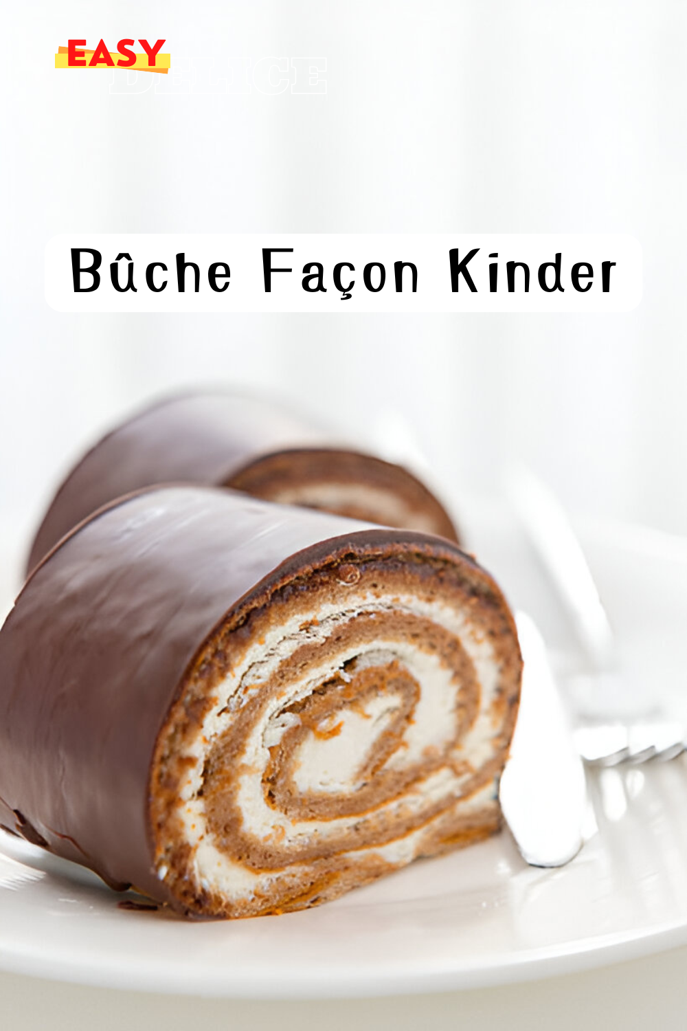  Une bûche façon Kinder, garnie de crème chocolatée, recouverte d’un glaçage brillant, et décorée de noisettes et éclats de chocolat.