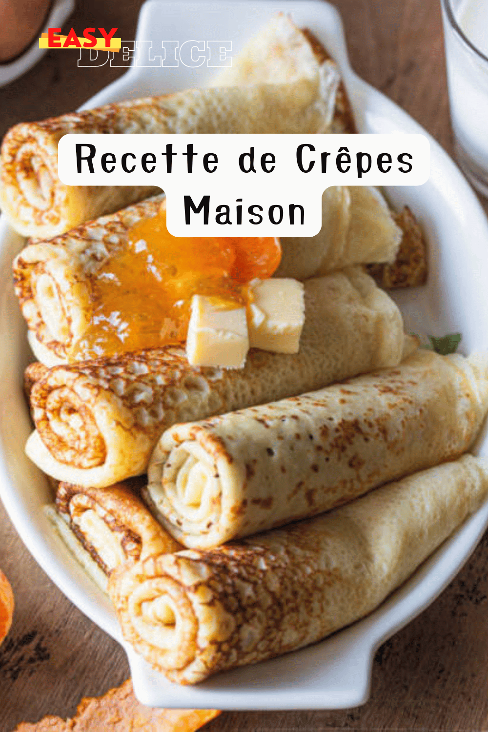 Une pile de crêpes maison dorées, garnies de Nutella et de fruits, sur une table avec un fouet et une casserole à côté.