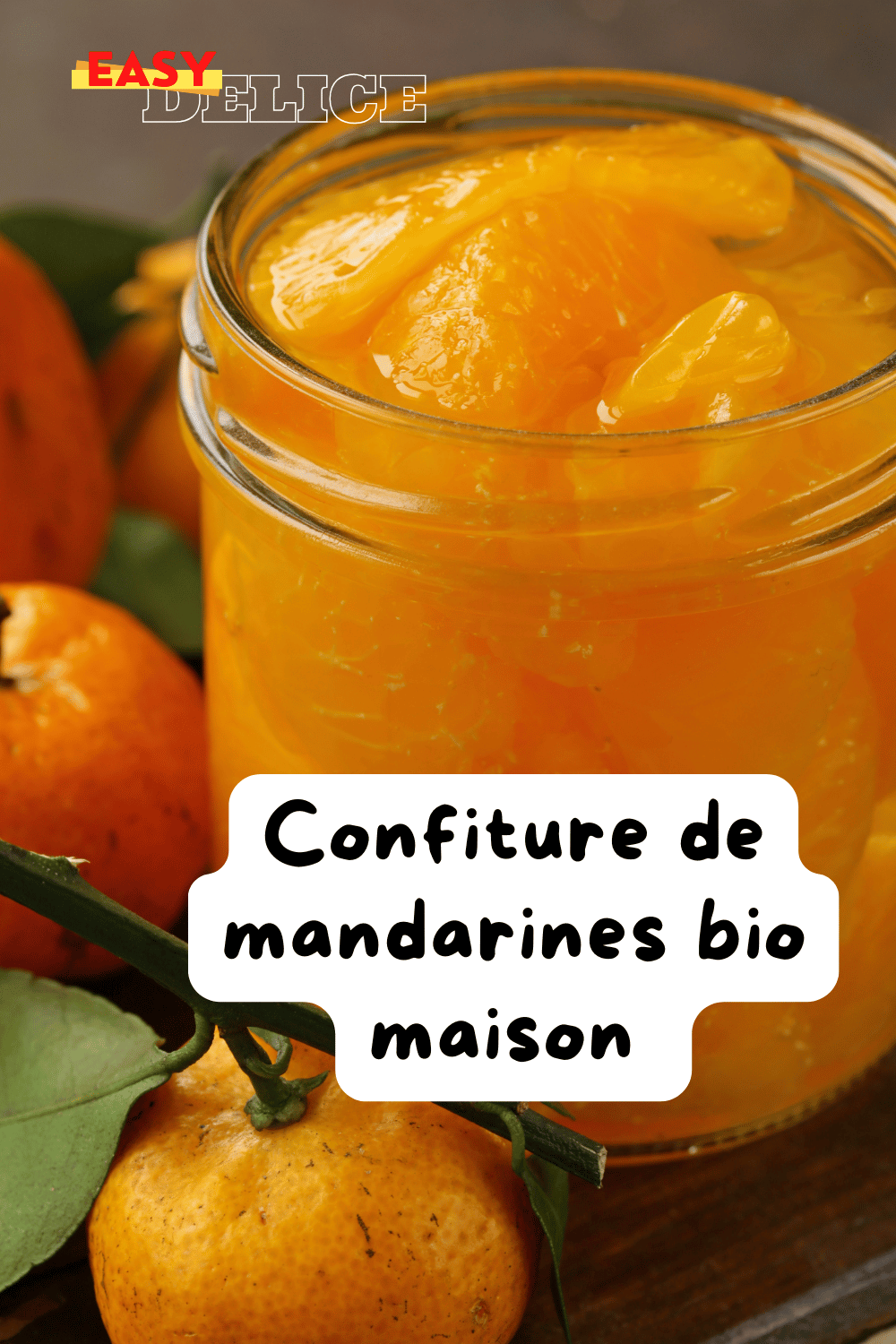 Pot de confiture de mandarines maison avec des tranches de mandarines fraîches et zestes.