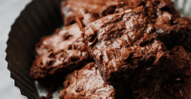 Brownie au chocolat cuit au Air Fryer, découpé en carrés et servi avec une boule de glace.