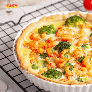 Une quiche dorée et appétissante aux crevettes et brocoli, tranchée et servie avec une salade verte.