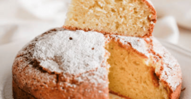 Gâteau doré et moelleux sans beurre ni huile, tranché sur une assiette ensoleillée.