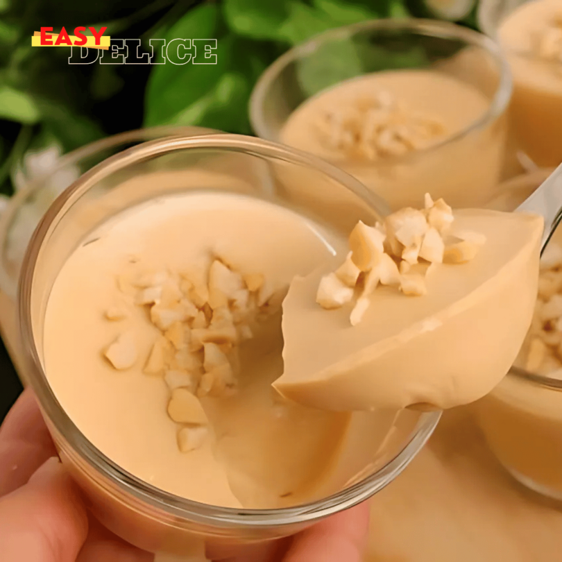 Dessert à 3 ingrédients servi dans un verre, décoré de cacao et de noisettes.